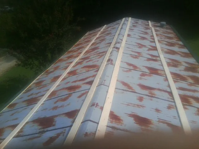 Rusted metal roof panels with new wood purlins before replacement — Storm Damage Roof Repair in Sixes by Roofing Brothers