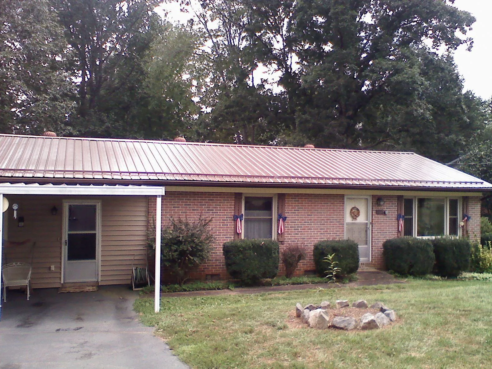 Bronze metal roof and carport on a brick ranch home — Roof Repair work by our crew in Sixes